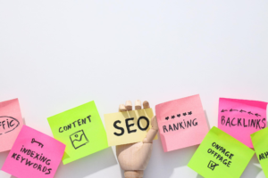 Sticky notes labelled SEO, content, ranking, backlinks and keywords arranged around a wooden hand